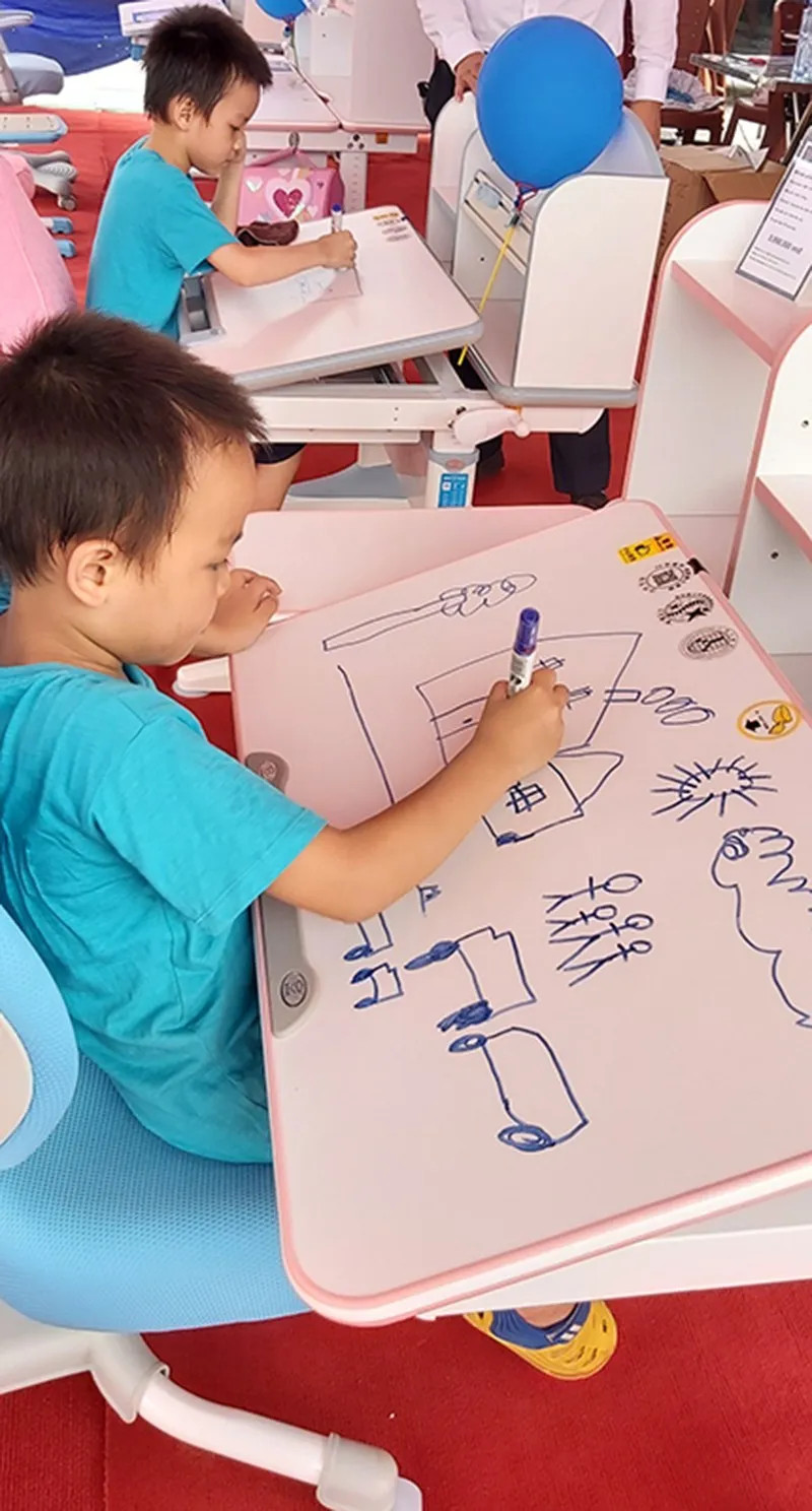 Các bé ngồi trải nghiệm sản phẩm bàn học thông minh